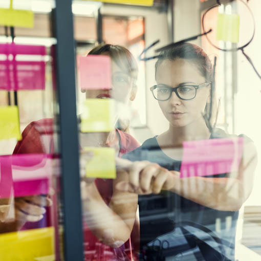 Two designers studying ideas board